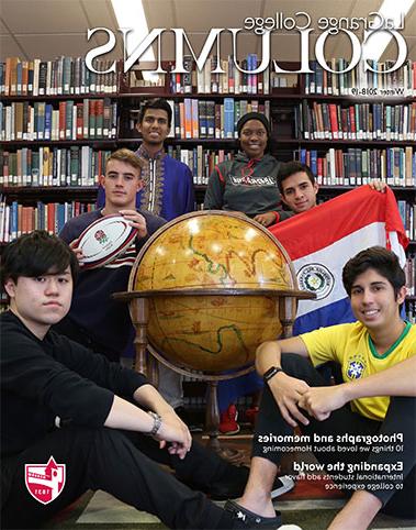 威尼斯人娱乐城专栏，六名国际学生坐在图书馆的书架上，拿着一个大地球仪